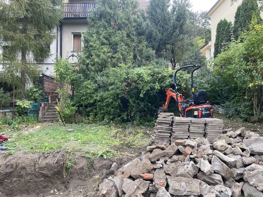 Bagr v zeleni, palety dlažby, Brno