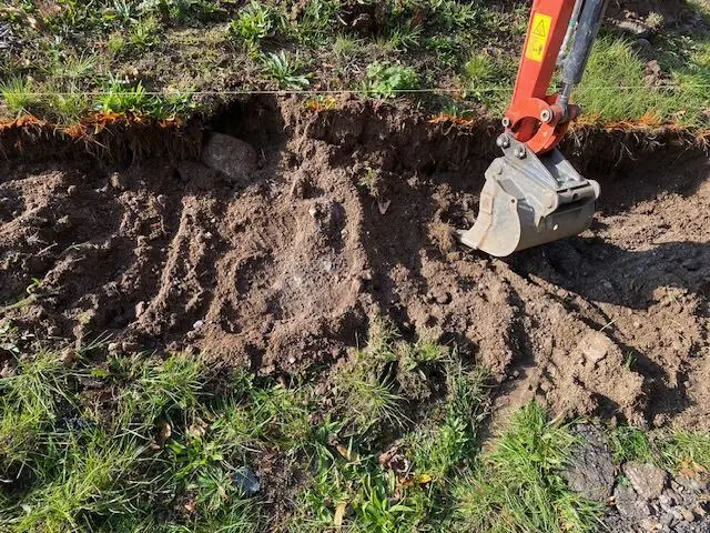 Bagr hloubí rýhu podél cesty, Nárameč