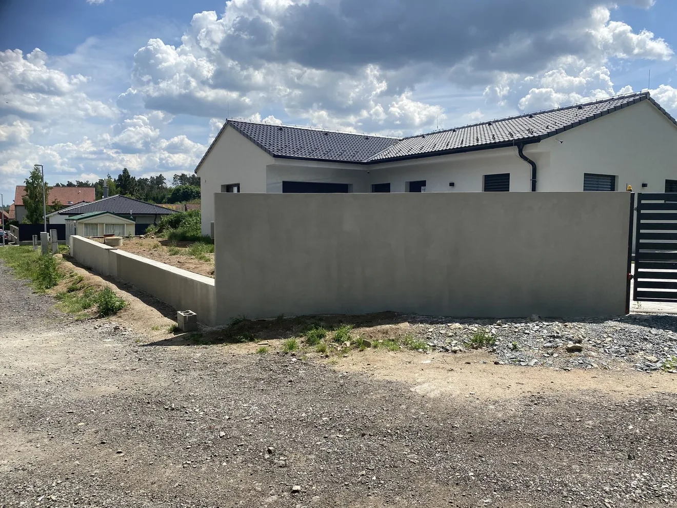 Hotová omítnutá opěrná zeď kolem předzahrádky novostavby